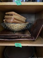 Wooden trays and glass bowl stacked inside a wooden corner tray on a shelf