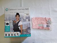 Front of original packaging for Contours Journey GO 5-in-1 baby carrier with a woman carrying a baby, alongside folded pink onesie with text 'Best Little Sister'.
