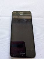 Front view of original Apple iPhone SE smartphone showing black screen with home button, slight smudges and dust visible.