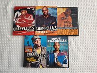 Front view of five Dave Chappelle DVDs showing front covers with photos and titles.