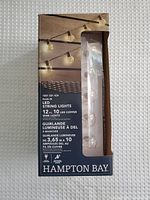 Front view of packaging showing the Hampton Bay LED string lights with 12 ft length and 10 LED bulbs on copper wire.
