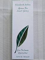 Closed white box with green leaf design and text: Elizabeth Arden Green Tea Scent Spray Eau Parfumée Vaporisateur 3.3 FL.OZ. 100 ml.