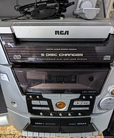 Front and top view of RCA stereo system showing 5 disc changer, cassette decks, and control panel.