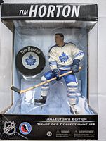 Front view of boxed Tim Horton NHL figurine showing figure and included puck through clear display window with Collector's Edition text
