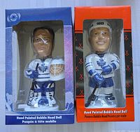 Photo showing both Curtis Joseph and Mats Sundin bobbleheads in original boxes, facing forward, with Curtis Joseph on the left and Mats Sundin on the right.