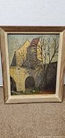 Front view of framed oil painting showing church building scene
