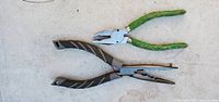Two smaller needlenose pliers, one black-handled and one green-handled, placed on a light surface.