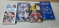 Photo of four sealed NFL VHS sports videos front covers: Sports Illustrated 1994 The Year in Sports, Dallas Cowboys Edge, Sports Illustrated 1995 Year in Sports, and A Playbook for Giants.