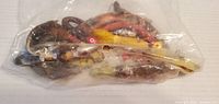 Plastic bag of various Slatwater bucktail fishing lures in assorted colors and sizes, packed together.
