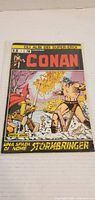 Front cover of the Conan Stormbringer comic book featuring a duel between Conan and a red-hooded opponent.