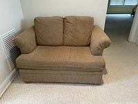 Front view of beige traditional loveseat showing two seat cushions and two back cushions, all removable, set against a white wall.