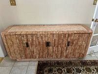 Front view showing four doors clad in pink marble mosaic and black metal handles