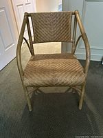 Front view of the natural wicker accent chair showing woven seat, back and wood frame