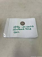 Image of the 1896 Newfoundland 20 cent coin inside a plastic sleeve labeled in green ink.
