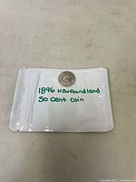 Coin in protective packaging with label reading '1896 Newfoundland 50 cent coin'.