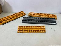 Four magnetic socket organizers by Mulwark in orange and gray with multiple labeled holes for different socket sizes.