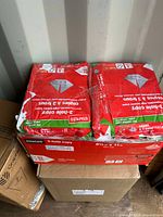 Photo showing four unopened reams of Staples 3-hole punched copy paper, 8.5 x 11 inches, stacked in a box.