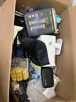 View of box top showing hair clipper/shaver box, black case, and small items.