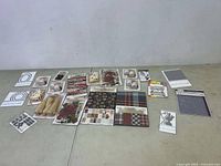 Wide view of all craft items laid out on floor, showing an assortment of paper sheets, embellishments, and die sets.