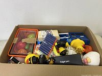 Full box view showing assorted mostly new children's toys and items including food set and darts.
