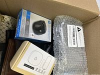 Top view of box showing HP wireless mouse box, wireless door chime, and bubble wrapped item