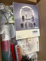 Box with Apple MagSafe accessories in original packaging along with other miscellaneous items