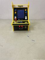 Front view of the yellow mini Pac-Man arcade cabinet showing screen and control panel.