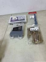 Overview of all items: 19-piece drill bit set, clutch puller packaging, bag of bolts/screws