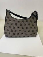 Front view of vintage Dooney & Bourke small purse showing beige logo monogram fabric and black leather trim.