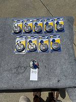 Photo showing ten sealed disc padlocks laid out on a grey surface, each with keys attached and on branded backing cards.