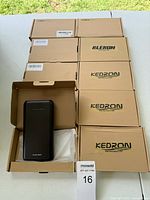 10 boxed power banks stacked on table, one open showing black power bank labeled 'Power Bank'