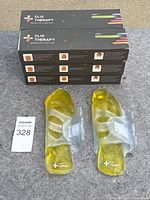 Six boxed pairs of Clix Therapy gel foot packs stacked with two gel foot packs out of the box displayed in front.