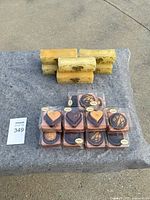 Five rectangular decorative soaps with yellow honeycomb and bee designs on a gray fabric surface.