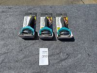 Three Gaiam Restore Cold Therapy Massage Rollers in original packaging placed on a dark grey cloth.