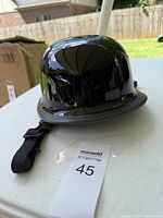 Glossy black helmet with outer shell and chin strap detail.