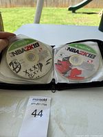 Basket with binder open showing NBA 2K19 and NBA 2K18 game discs for Xbox One