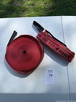 Red slackline webbing rolled on white surface with GIBBON branded carrying bag