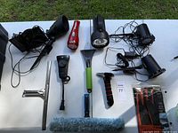 Full view of flashlights, cleaning tools, ice scrapers, glove, and cables spread on table.