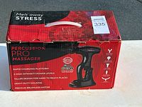 Box exterior showing Percussion Pro Massager branding and features such as rapid charging, 3 intensity levels, and premium brushless motor.