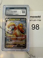 Photo of Japanese Dragonite V Pokémon card in CGC hard case graded Gem Mint 10. Shows front holo artwork with CGC label including card name, grade, series and number.