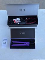Photo showing both Soleil branded boxes, one containing the heated hair brush and the other the purple mini flat iron.