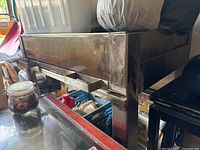 Front view of stainless steel charcoal grill on storage shelf