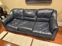 Full view of three-seat dark navy leather sofa
