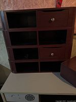 Stacked dark wood salon cabinets showing open cubbies and drawers