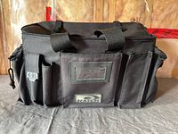 Front view of black Hatch engineer’s bag showing handles, zip closure, logo patch and front tool pockets