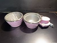 Set showing two pink freezer bowls, paddle inside one bowl, motor base with cord