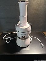 Front view of the Jack LaLanne Power Juicer showing full unit, locking bar, feed tube and power cord