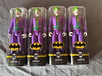 Front view of four sealed Joker figures showing character design and packaging