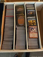 Open three-row card storage box filled with Magic: The Gathering cards