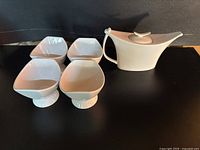 full set showing four pedestal bowls and teapot with lid